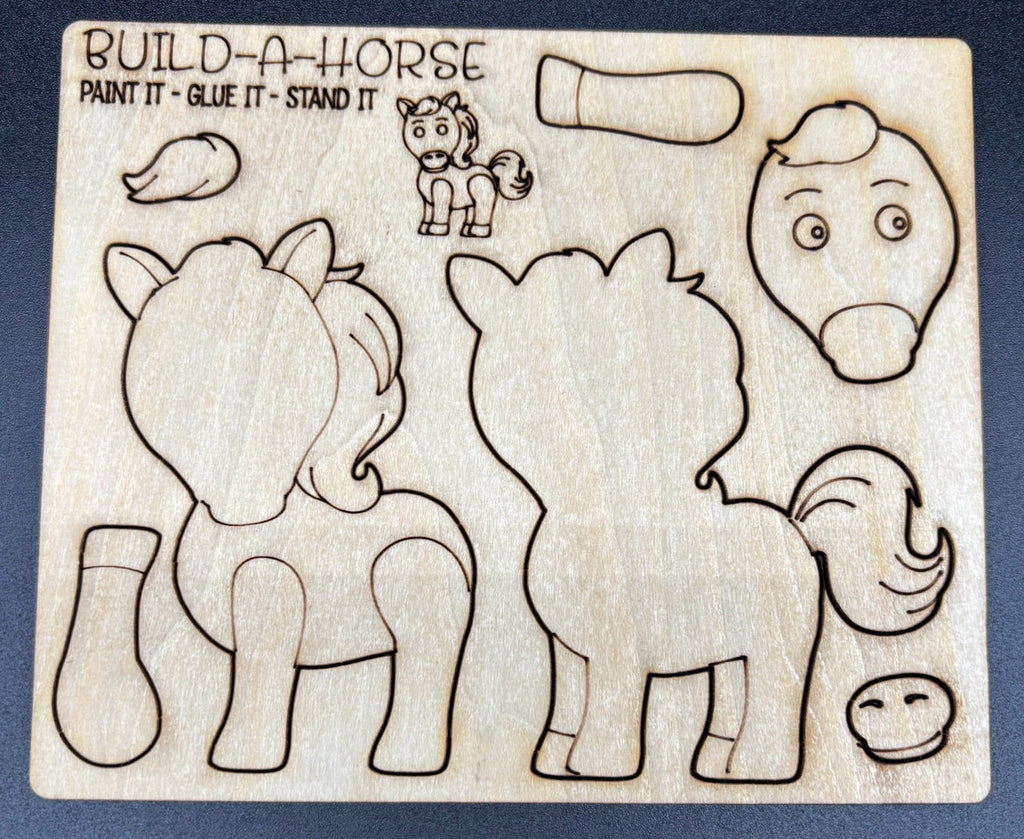 A wooden DIY craft kit labeled 'BUILD-A-HORSE' with engraved outlines of a horse body parts and a small cartoon horse, shown on a dark textured background.